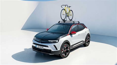 Illustrazione di una Opel Mokka con vari accessori esterni installati, come barre portatutto, spoiler e cerchi in lega personalizzati.