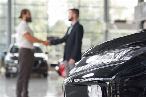 Un direttore commerciale che guida una riunione di vendita in una concessionaria auto.