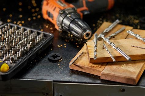 Uomo che testa un trapano tassellatore su un blocco di legno