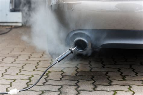 Tecnico che esamina i gas di scarico del veicolo