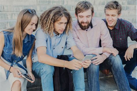 Un gruppo di giovani che guardano uno smartphone in un ambiente urbano