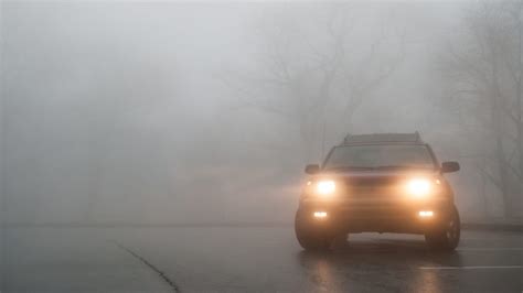 Illustrazione di un veicolo che attraversa la nebbia con i fendinebbia accesi