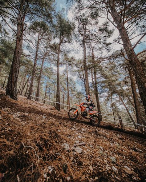 Motociclista di enduro con paramani in azione su un sentiero sterrato