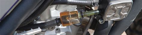Motociclista che controlla il filtro benzina della sua moto