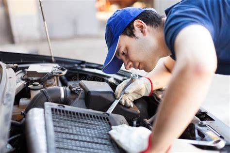 Meccanico specializzato che ispeziona un motore di automobile con strumenti diagnostici
