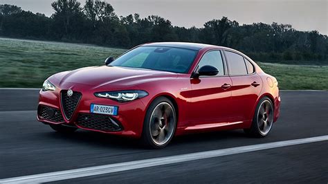 Alfa Romeo Giulia parcheggiata davanti a una moderna concessionaria con logo Alfa Romeo