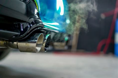 Un'immagine che mostra un'auto moderna con un'enfasi sul suo sistema di scarico e sensori ambientali.