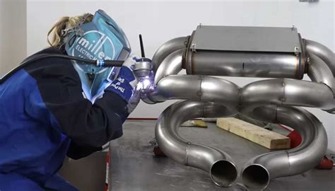 Tecnico che installa un sistema di scarico su un'auto