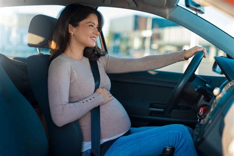 Donna incinta alla guida con cintura di sicurezza correttamente posizionata