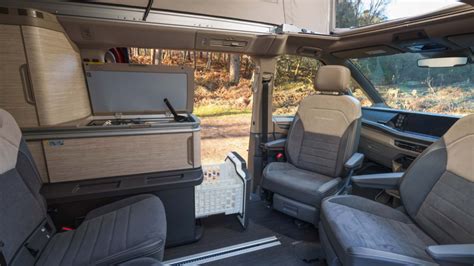Interior view of a Volkswagen California van showing the sleeping area and kitchenette