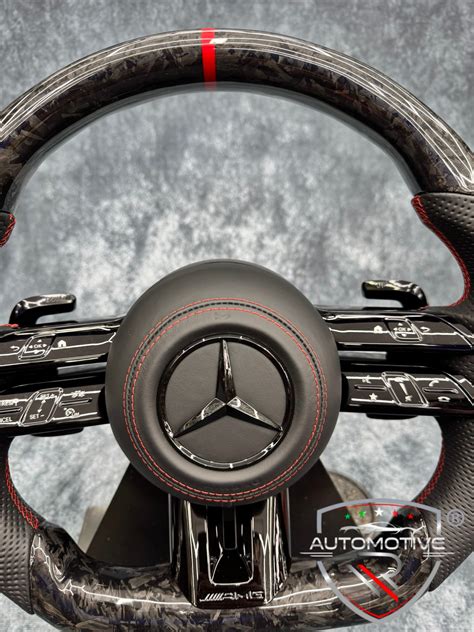Dettaglio del volante sportivo AMG rivestito in MICROCUT e inserti in carbonio