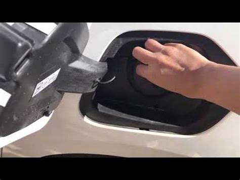Persona che pulisce il tappo del serbatoio dell'auto