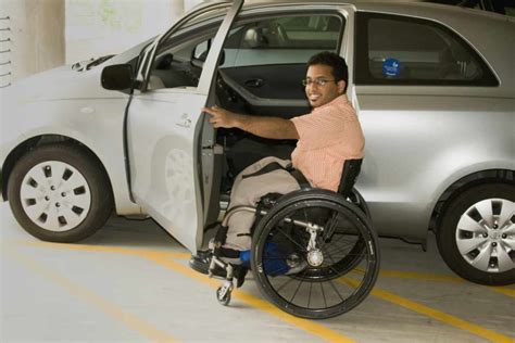Persona disabile che sale in auto adattata