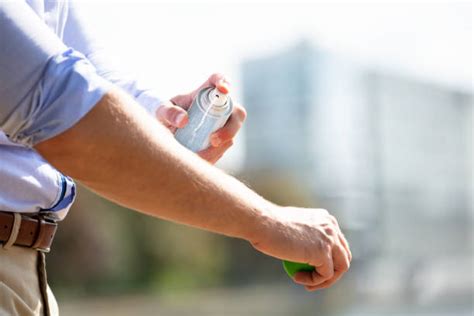 Uomo che spruzza spray al silicone sulle guarnizioni di una porta d'auto