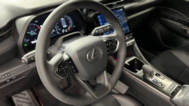Cruscotto digitale di una Lexus, che mostra le informazioni di guida in tempo reale, inclusi i dati sull'energia ibrida e le modalità di guida selezionate.