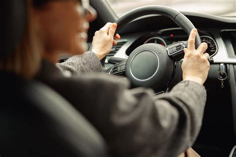 Mano che tiene un volante con un'espressione preoccupata