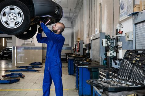 Interno di un'officina automobilistica moderna con meccanici al lavoro