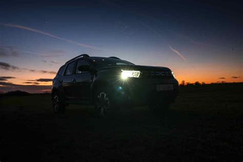 Ford EcoSport su strada al tramonto con fari accesi