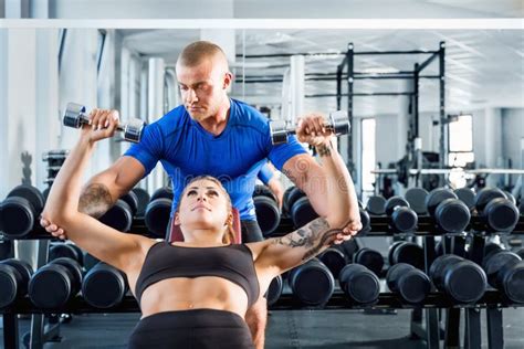 Personal trainer che assiste un cliente in palestra