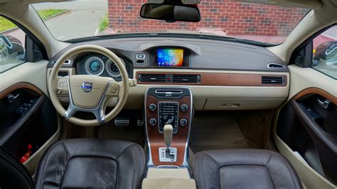 Interior view of a Volvo XC70 showing the driver's door panel with mirror controls