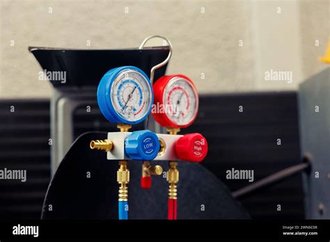 Meccanico che controlla la pressione del gas refrigerante con manometri