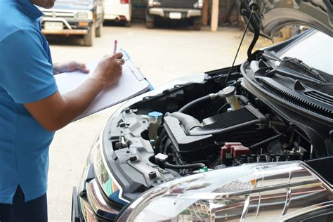 Car mechanic inspecting car key and electronic system