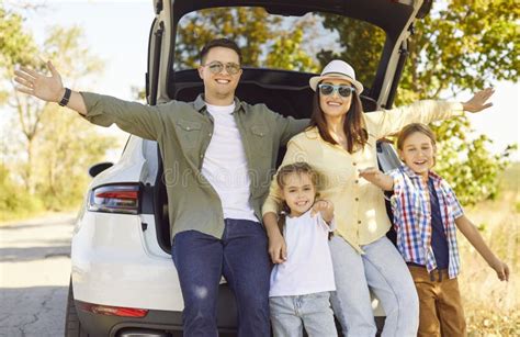 Famiglia felice accanto a un'auto a noleggio