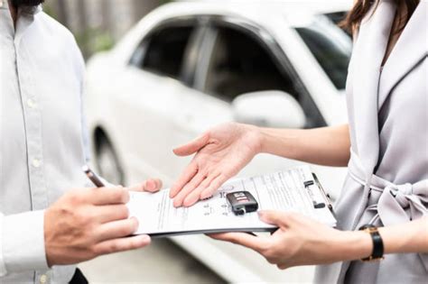 Agente di vendita automobilistico che mostra un'auto a un cliente in un concessionario