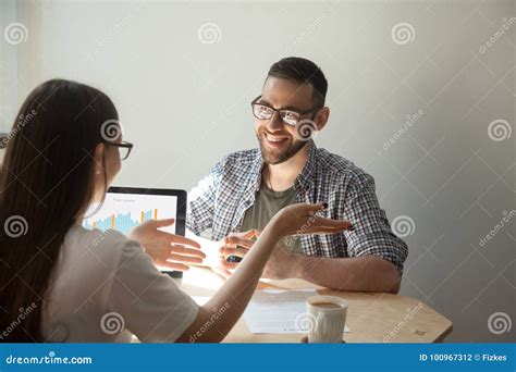 Due persone in riunione che discutono di grafici e statistiche.