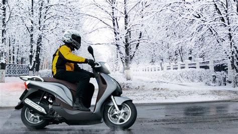 Motocicletta in strada innevata con pneumatici invernali M+S