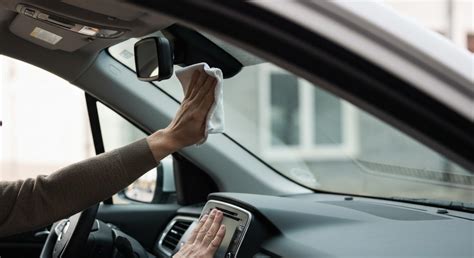 Persona che pulisce il vetro dell'auto