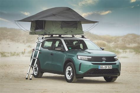 Tenda da tetto aperta su un SUV in un paesaggio naturale