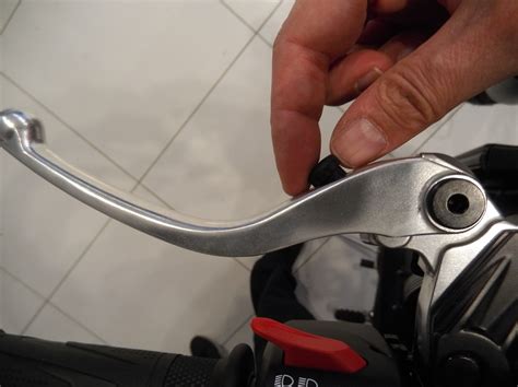 Motociclista che regola la leva della frizione