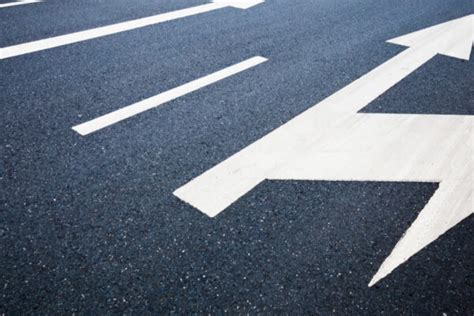 Una strada asfaltata a più corsie con segnaletica orizzontale e verticale