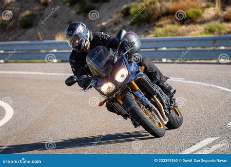 motociclista in curva su asfalto bagnato