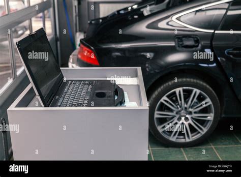 meccanico professionista che utilizza computer diagnostico su motore bmw
