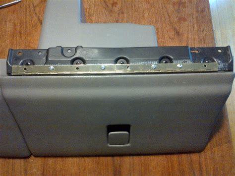 Close-up of a damaged glove box hinge