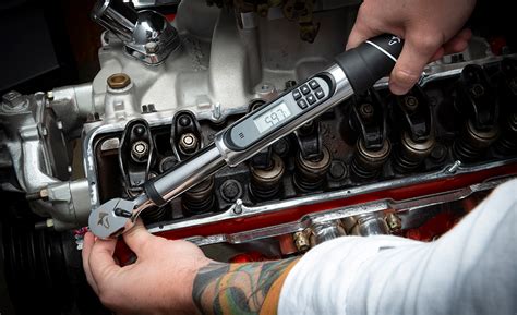 Man at work: Tightening bolts on an engine with a torque wrench