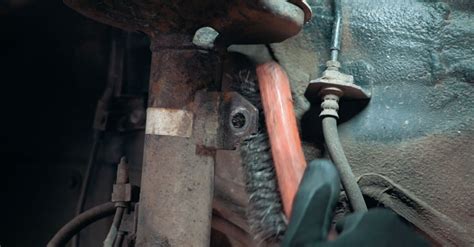 Primo piano di un gommino della barra stabilizzatrice usurato e danneggiato