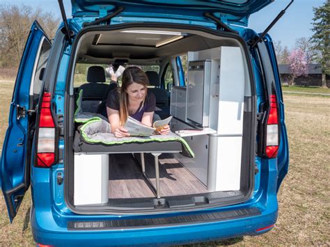 Interno di un Volkswagen Caddy camperizzato con letto esteso
