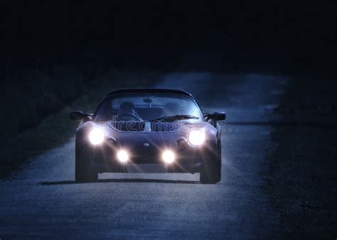 Auto che guida di notte con fari accesi