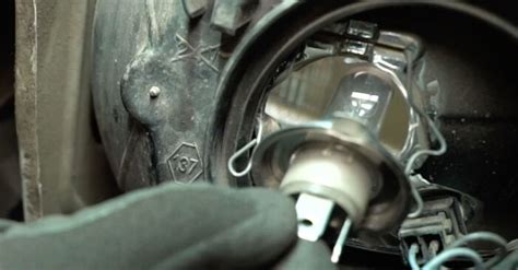Schema che mostra come rimuovere e installare una lampadina del faro auto