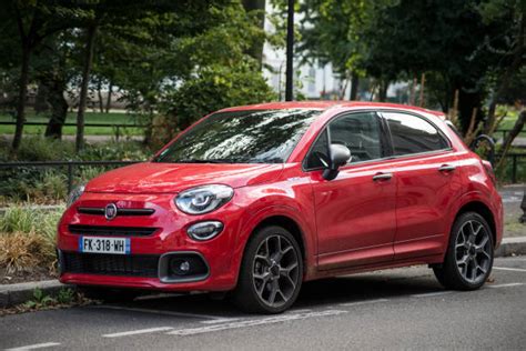 Una Fiat Coupé rossa parcheggiata in una strada urbana