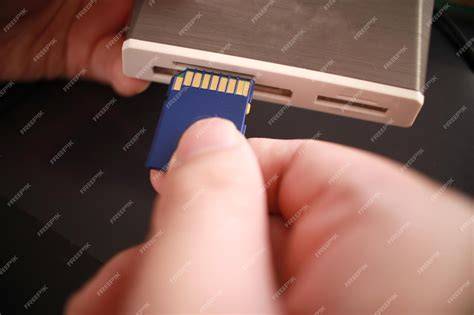 A hand inserting an SD card into a car dashboard