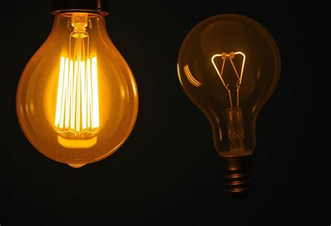 Mani che tentano di raggiungere una lampadina nel vano motore di un'auto
