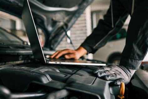 Meccanico che esegue una diagnosi su una Volvo con computer