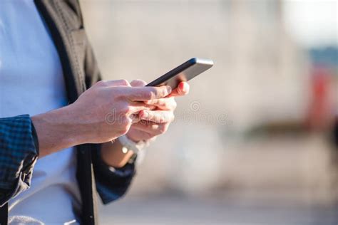 Uomo che usa un feature phone all'aperto