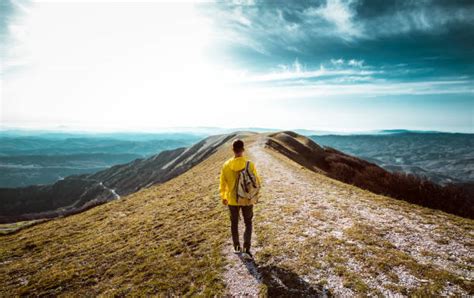 Persona con zaino da viaggio sulle spalle in un paesaggio naturale