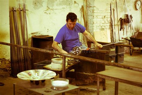 Artigiano al lavoro su un componente di un'auto d'epoca