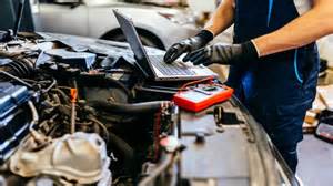 Meccanico che esegue una diagnosi elettronica su un motore
